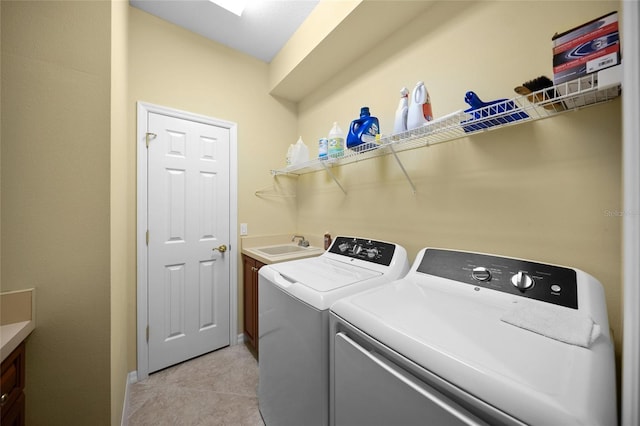 clothes washing area featuring cabinets, independent washer and dryer, sink, and light tile patterned floors