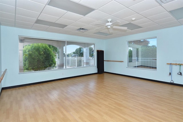 empty room with a paneled ceiling, ceiling fan, and light wood-type flooring