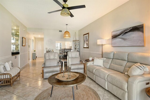 living room with a wealth of natural light, light tile patterned flooring, and ceiling fan