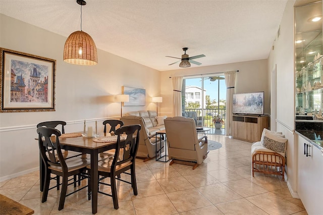 tiled dining area with ceiling fan and a textured ceiling