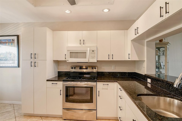 kitchen featuring white cabinets, sink, stainless steel range with electric cooktop, and dark stone counters