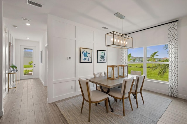 dining space featuring light hardwood / wood-style flooring and an inviting chandelier