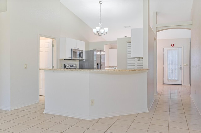 kitchen with light tile patterned floors, high vaulted ceiling, a notable chandelier, white cabinets, and appliances with stainless steel finishes