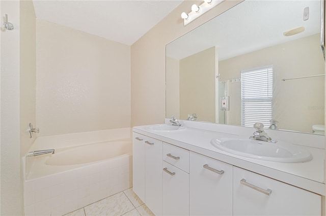 bathroom with tile patterned floors, tiled bath, and vanity