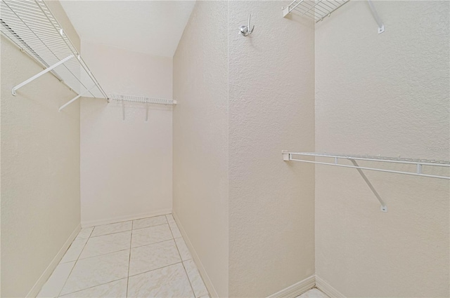 walk in closet with light tile patterned floors