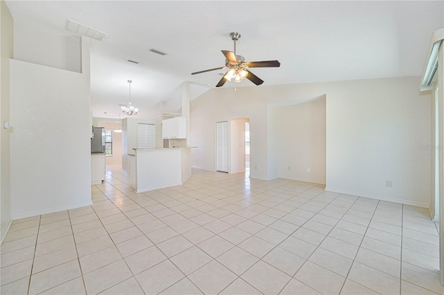 empty room with ceiling fan with notable chandelier, light tile patterned flooring, and lofted ceiling