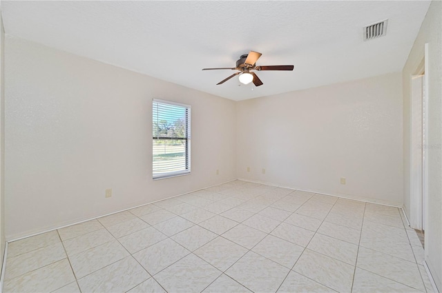 spare room featuring ceiling fan and light tile patterned floors