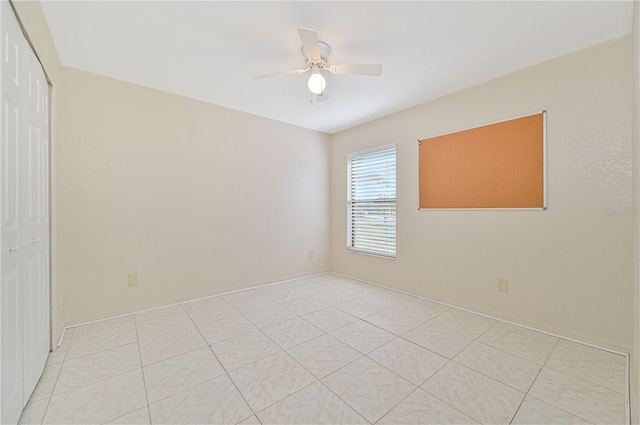 tiled spare room with ceiling fan