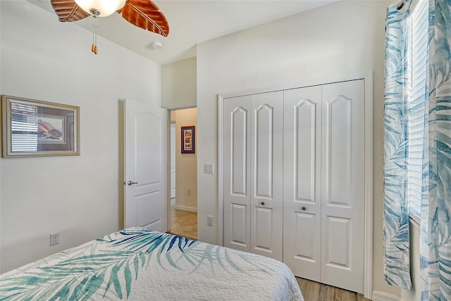 bedroom with a ceiling fan, a closet, and light wood-style flooring