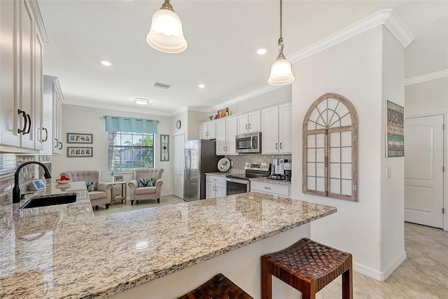 kitchen featuring a breakfast bar, crown molding, stainless steel appliances, and a sink