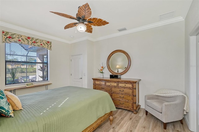 bedroom featuring ceiling fan, light wood-style flooring, visible vents, and crown molding