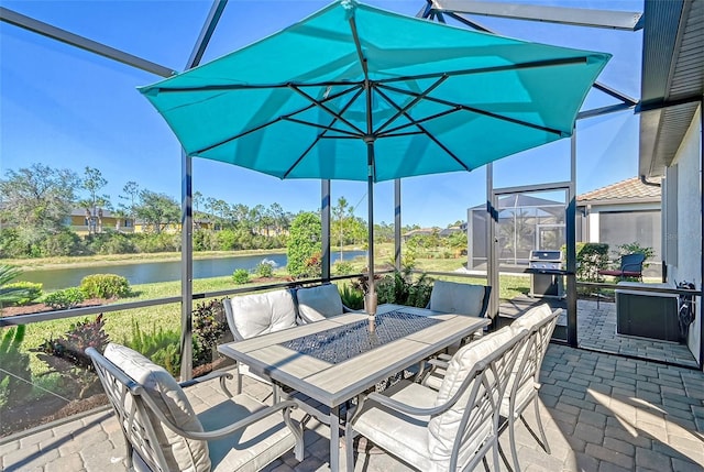 view of patio / terrace with a water view, glass enclosure, outdoor dining area, and area for grilling