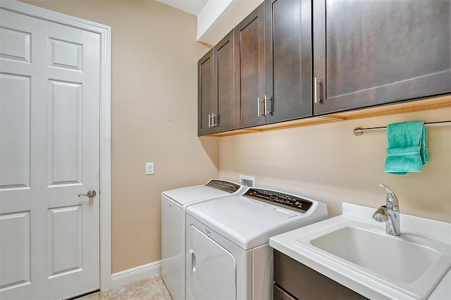 clothes washing area featuring cabinets, light tile patterned floors, sink, and washing machine and clothes dryer