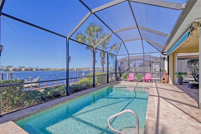 view of pool with glass enclosure, a patio area, and a water view