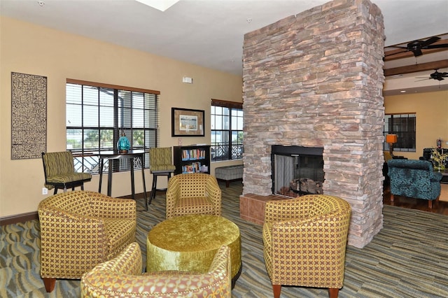 living room with beam ceiling, ceiling fan, a fireplace, and wood-type flooring