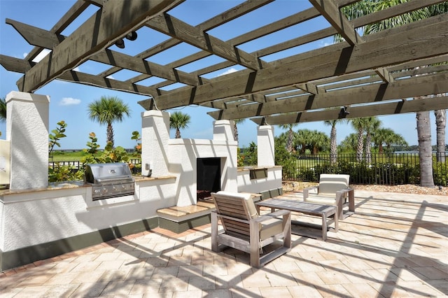 view of patio / terrace featuring exterior kitchen, exterior fireplace, a pergola, and grilling area