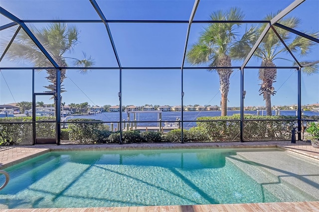 view of pool featuring glass enclosure and a water view