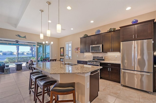 kitchen with a center island with sink, stainless steel appliances, plenty of natural light, and sink