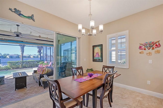 dining area featuring a wealth of natural light, light tile patterned floors, and ceiling fan with notable chandelier