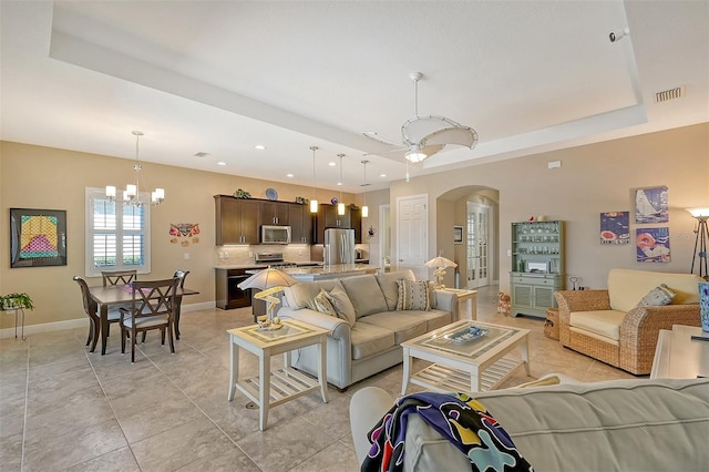 1014 Overlook Ct, Bradenton, FL 34208 - living area featuring arched walkways, a chandelier, recessed lighting, light tile patterned flooring, and a raised ceiling