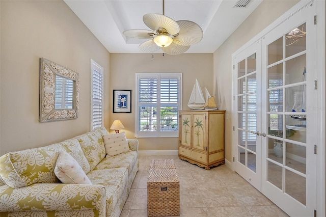 tiled living room with french doors and ceiling fan