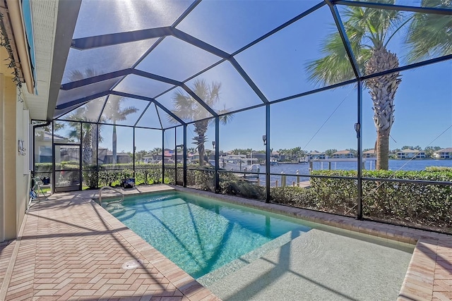 view of pool with glass enclosure, a water view, and a patio