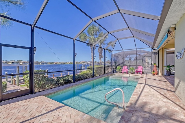 view of pool with a patio, a water view, and a lanai