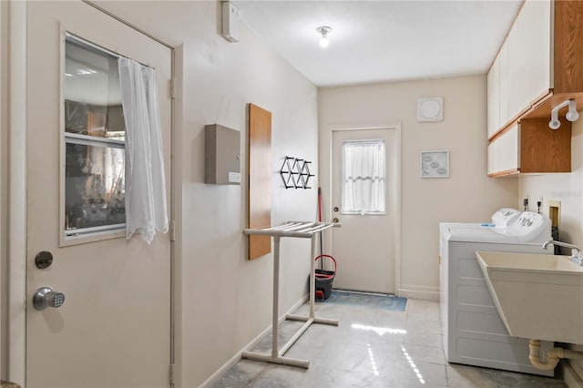 clothes washing area with cabinets, sink, and washing machine and clothes dryer