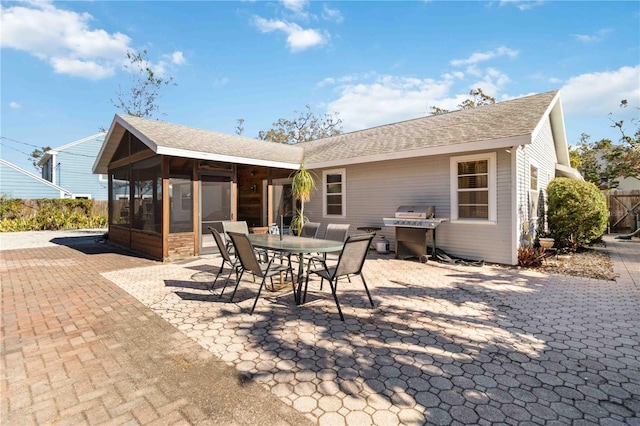 back of property with a sunroom and a patio