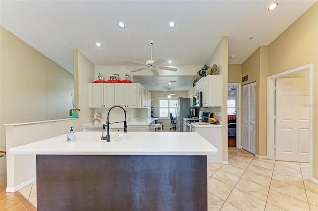 kitchen featuring a center island, stainless steel appliances, white cabinetry, and ceiling fan