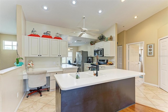 kitchen featuring appliances with stainless steel finishes, vaulted ceiling, ceiling fan, light tile patterned floors, and white cabinets