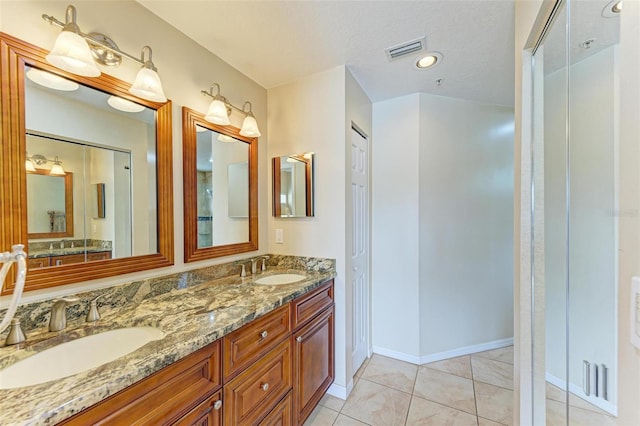 bathroom featuring tile patterned flooring, vanity, and a textured ceiling