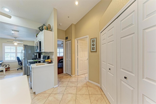 kitchen featuring ceiling fan, light tile patterned flooring, a textured ceiling, white cabinets, and appliances with stainless steel finishes