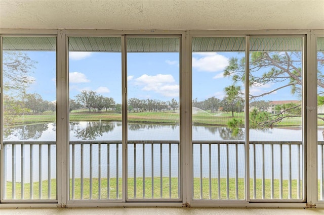 unfurnished sunroom featuring a water view