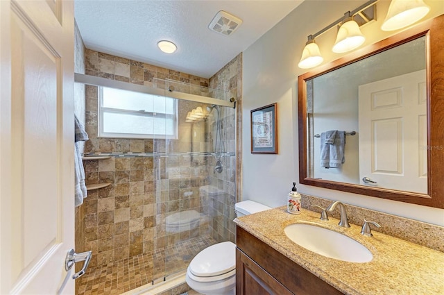 bathroom with toilet, an enclosed shower, a textured ceiling, and vanity