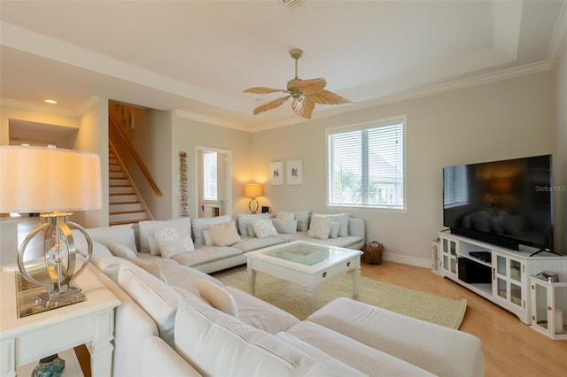 living room with light hardwood / wood-style floors, ceiling fan, and crown molding