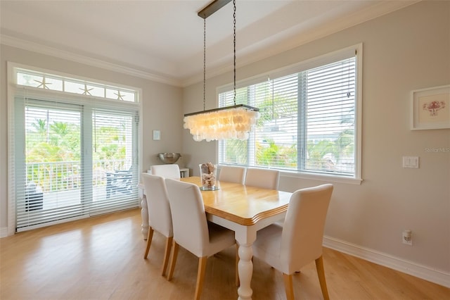 dining area featuring an inviting chandelier, ornamental molding, and light hardwood / wood-style flooring