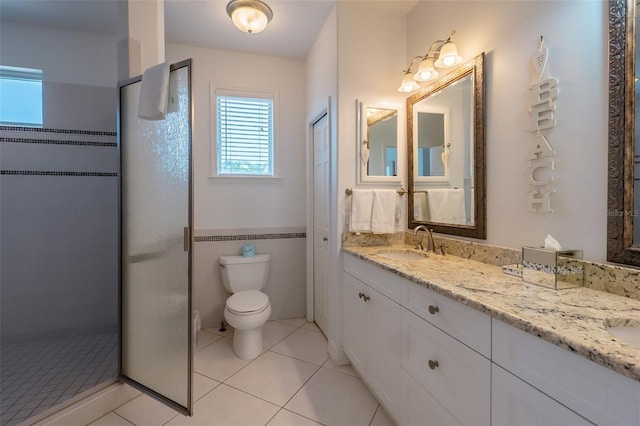 bathroom with tile patterned floors, toilet, vanity, and tiled shower