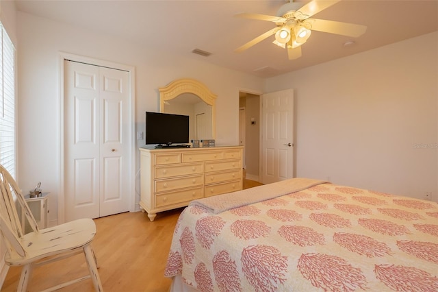 bedroom with ceiling fan, light hardwood / wood-style floors, and a closet