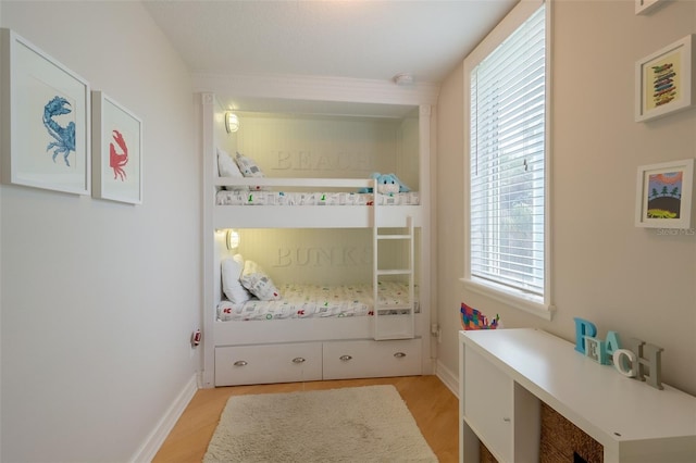 bedroom with light wood-type flooring and multiple windows