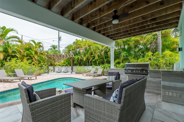 view of patio / terrace featuring an outdoor kitchen, area for grilling, a fenced in pool, and ceiling fan