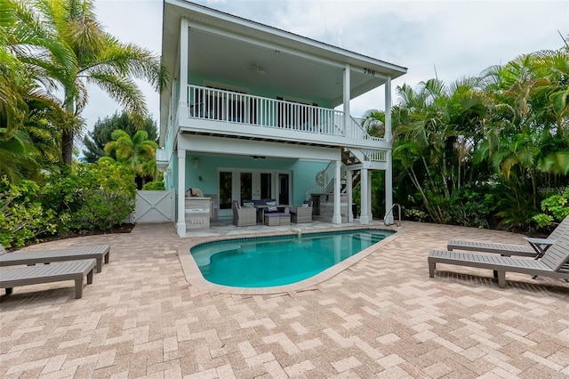 back of property with french doors, a balcony, ceiling fan, and a patio area