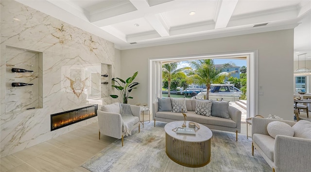 living room with coffered ceiling, a premium fireplace, beamed ceiling, crown molding, and tile walls