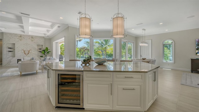 kitchen featuring white cabinets, a kitchen island, beverage cooler, and decorative light fixtures