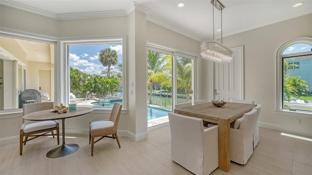 dining room with light tile patterned flooring, a water view, ornamental molding, and a chandelier