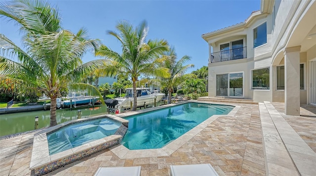 view of swimming pool featuring a patio area, a water view, and an in ground hot tub