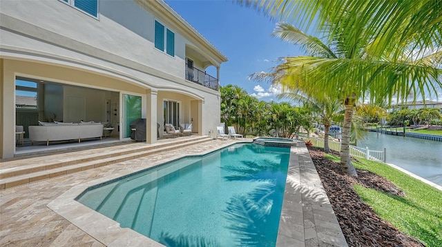 view of pool featuring an in ground hot tub, a water view, and a patio area