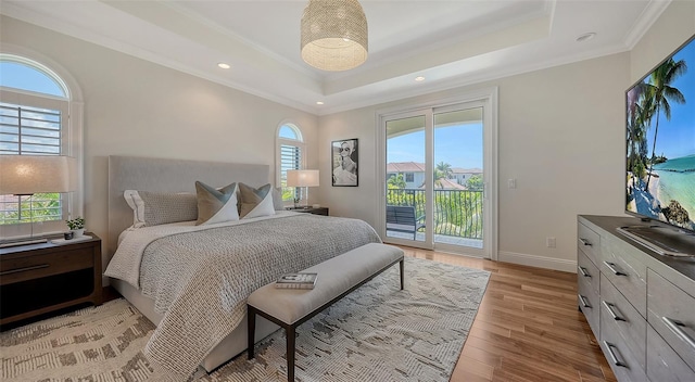 bedroom with a raised ceiling, access to exterior, ornamental molding, and light wood-type flooring