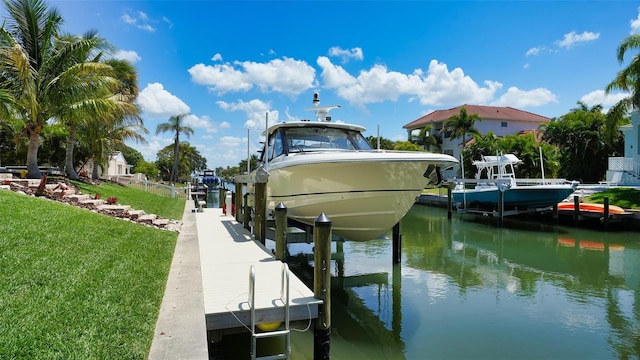 view of dock with a lawn and a water view