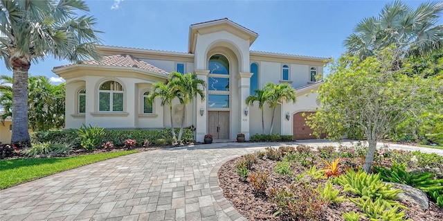 510 Bowsprit Ln, Longboat Key, FL 34228 - mediterranean / spanish home featuring driveway, stucco siding, a garage, and a tile roof